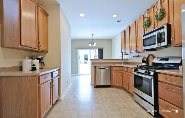 a kitchen with stainless steel appliances granite countertop a stove a sink and a refrigerator