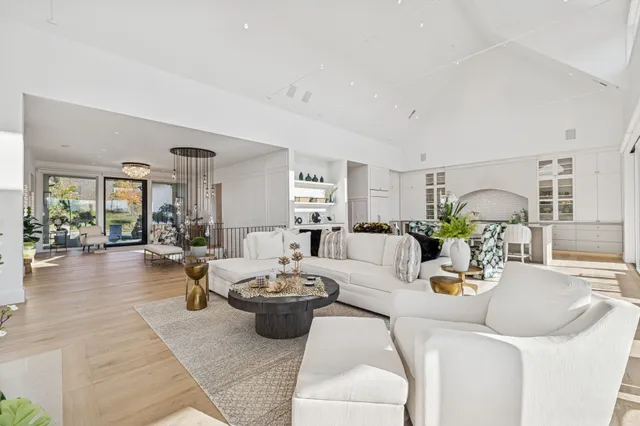 a view of a hallway to a livingroom with wooden floor and furniture