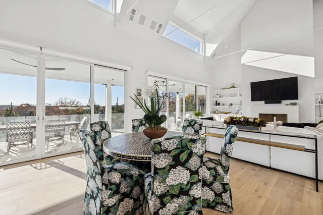 a view of a hallway with wooden floor and a bathroom