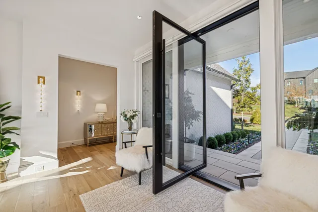 a living room with furniture and potted plants