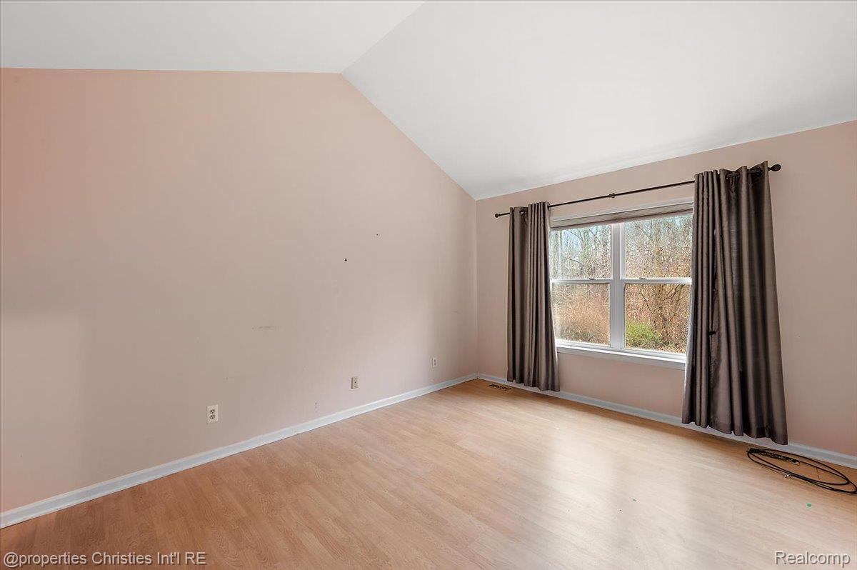 955 Rikki Ann Court Wixom, MI 48393 - Photo 37 of 54 Spare room with light wood finished floors and vaulted ceiling