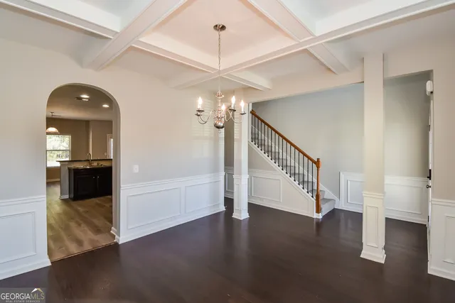 a view of a kitchen with kitchen island a sink stainless steel appliances and a chandelier