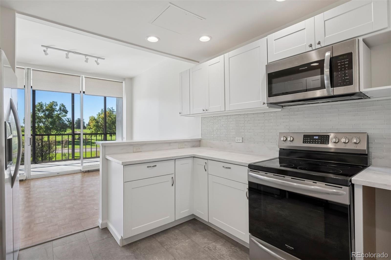 1201 North Williams Street, Unit 2A Denver, CO 80218 - Photo 7 of 29 a kitchen with stainless steel appliances white cabinets and a stove top oven
