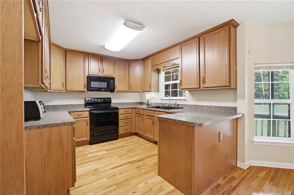 12 Whispering Pines Northeast Rome, GA 30161 - Photo 14 of 57 a kitchen with granite countertop wooden cabinets a stove top oven and stainless steel appliances