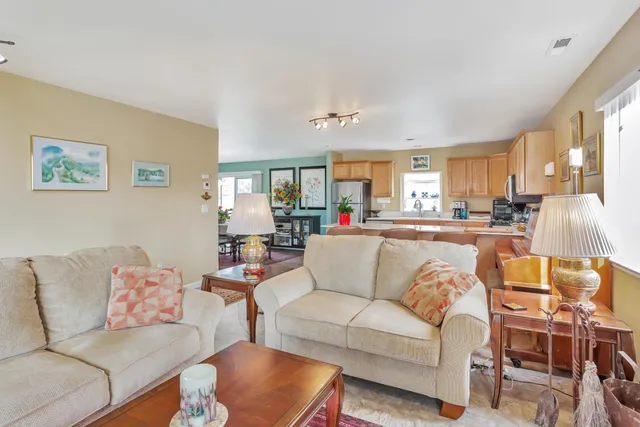 a kitchen with stainless steel appliances kitchen island granite countertop a table and chairs in it