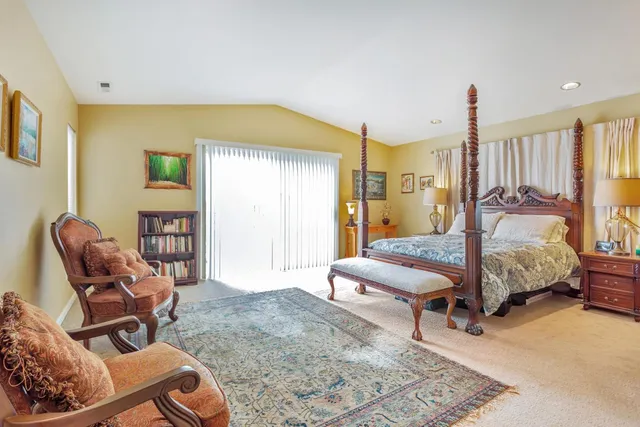 a bedroom with a bed and dresser next to a window