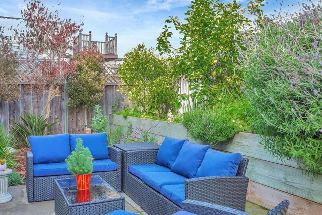 a patio with table and chairs and potted plants