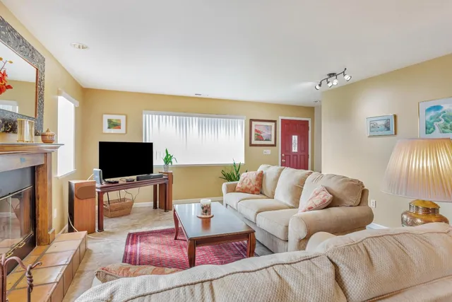 a living room with furniture and a view of kitchen