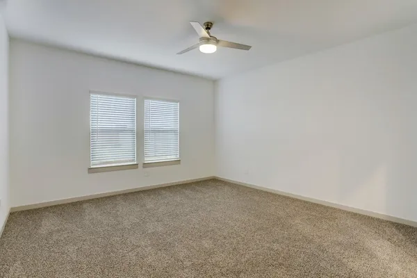 an empty room with a window and a ceiling fan