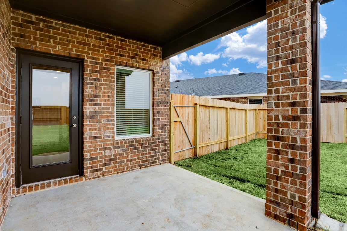 29866 Wildcat Way Katy, TX 77494 - Photo 22 of 25 Relax and unwind on the covered backyard patio designed for comfortable outdoor living. Surrounded by classic brick construction and protected by a solid roof overhead, this space provides shade while enjoying fresh air and outdoor gatherings. The patio connects directly to the backyard and offers the perfect setting for outdoor seating, grilling, or morning coffee while enjoying views of the private fenced yard and open sky.