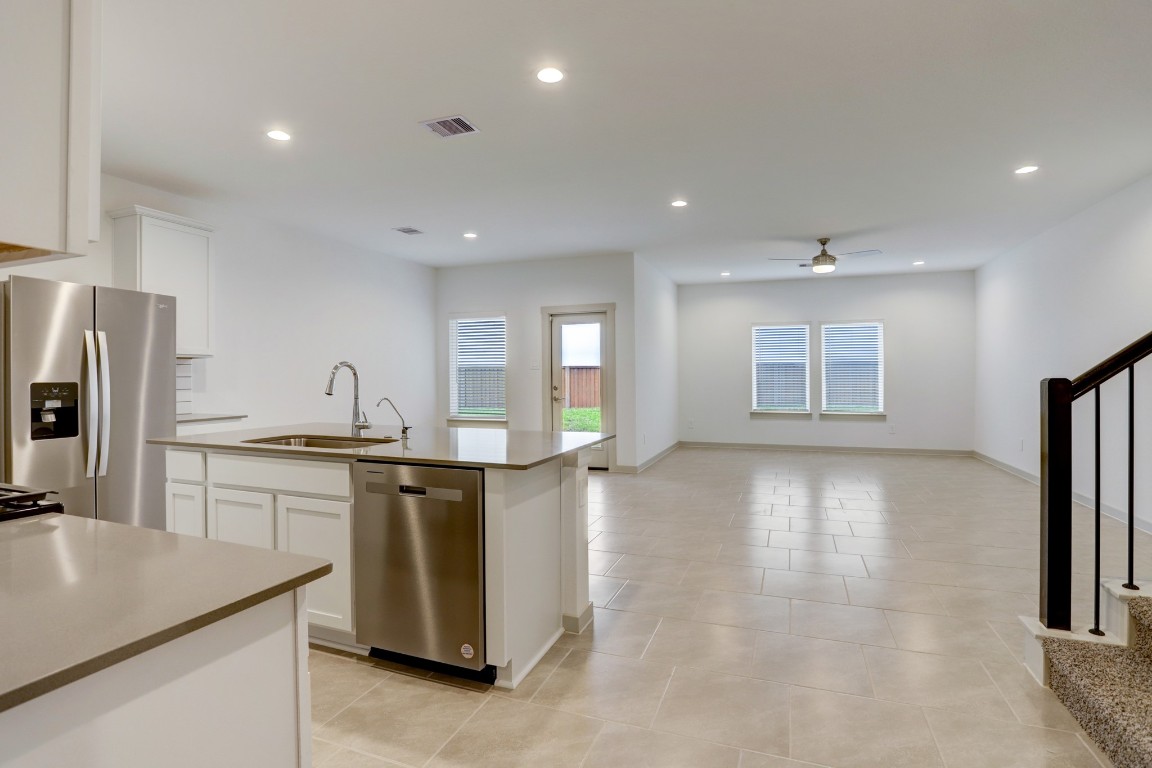 29866 Wildcat Way Katy, TX 77494 - Photo 3 of 25 Expansive open-concept living area that seamlessly connects the kitchen, dining, and family room. Large tile flooring flows throughout the main level, creating a cohesive and easy-to-maintain living space. Recessed lighting and multiple windows provide a bright and welcoming atmosphere, while the open layout allows for effortless entertaining and comfortable everyday living. The design offers flexibility for arranging furniture and creating a personalized living environment.
