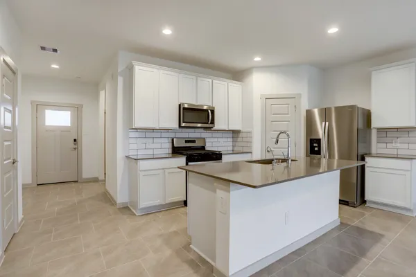 a kitchen with a refrigerator stove and microwave