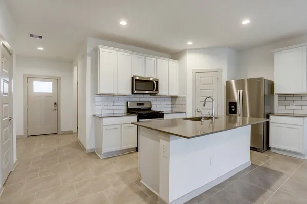 a kitchen with a refrigerator stove and microwave