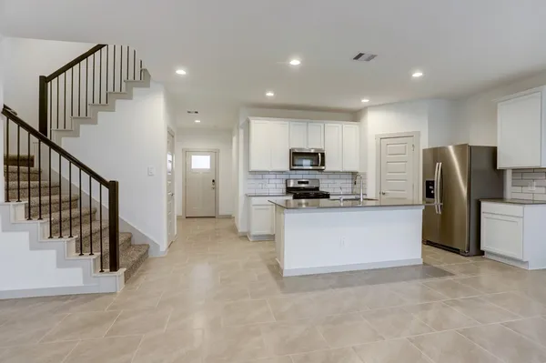 a view of kitchen with refrigerator and cabinets