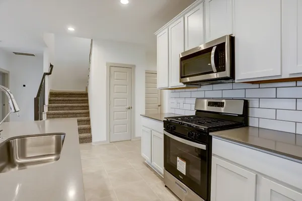 a kitchen with granite countertop a stove and a microwave