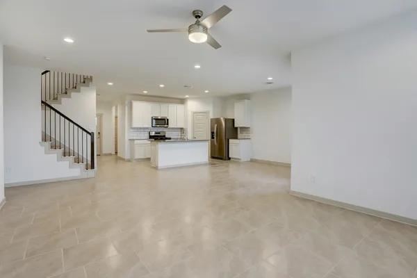 a view of a kitchen with wooden floor and a ceiling fan