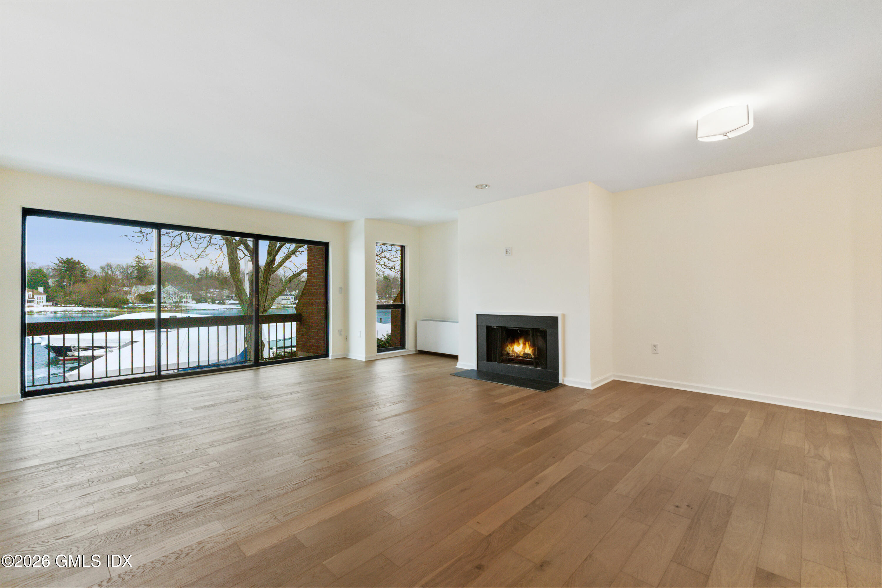 15 River Road, Unit 210 Cos Cob, CT 06807 - Photo 14 of 23 a view of an empty room with wooden floor and a fireplace