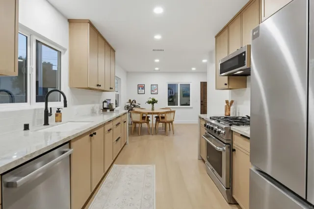 a kitchen with kitchen island granite countertop a sink a stove and cabinets