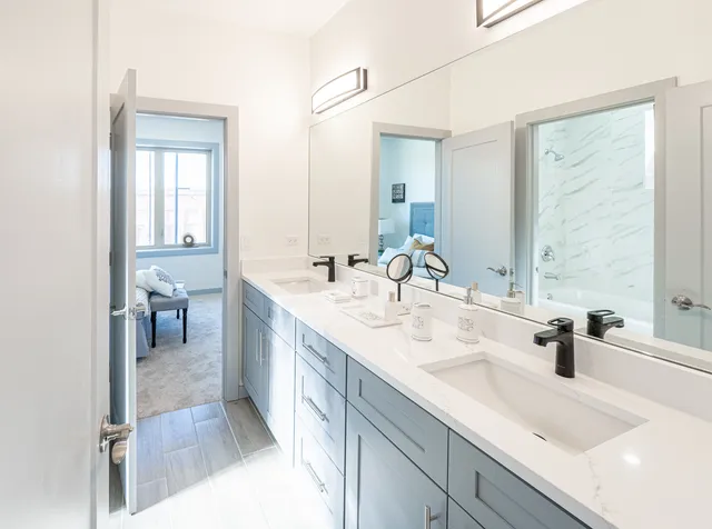 a bathroom with double vanity sinks and a mirror