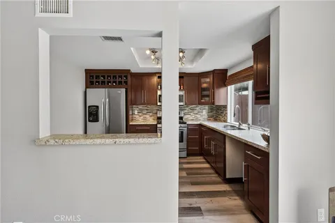 a large kitchen with a sink and dishwasher a stove with wooden floor