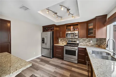 a kitchen with stainless steel appliances granite countertop a sink stove and refrigerator