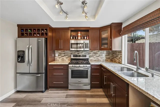 a kitchen with stainless steel appliances granite countertop a refrigerator and a sink