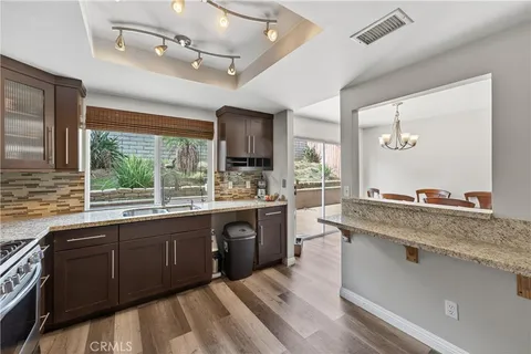a large kitchen with a sink and living room view