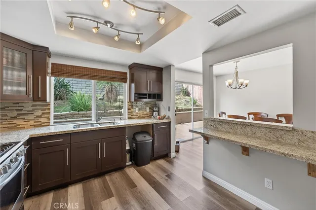 a large kitchen with a sink and living room view