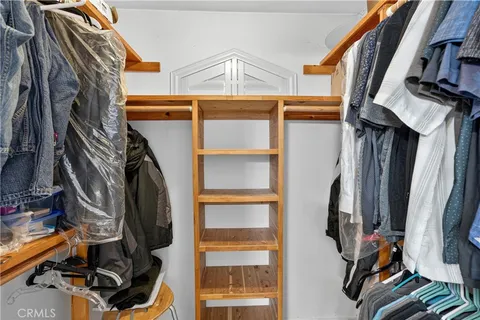 a view of walk in closet with clothes and shoes