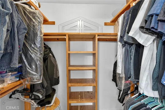 a view of walk in closet with clothes and shoes