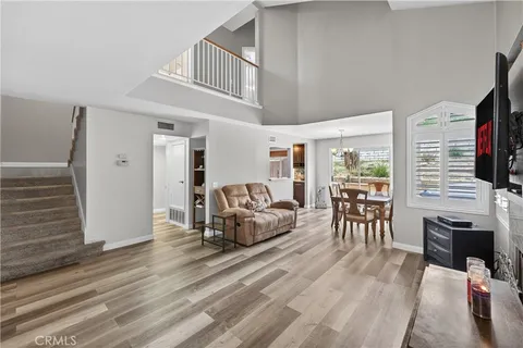 a living room with furniture a flat screen tv and a floor to ceiling window