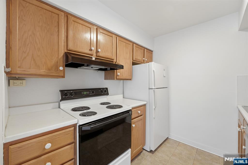 265 Main Street, Unit 704 Ridgefield Park, NJ 07660 - Photo 11 of 23 a kitchen with stainless steel appliances granite countertop white cabinets stove a refrigerator and a microwave