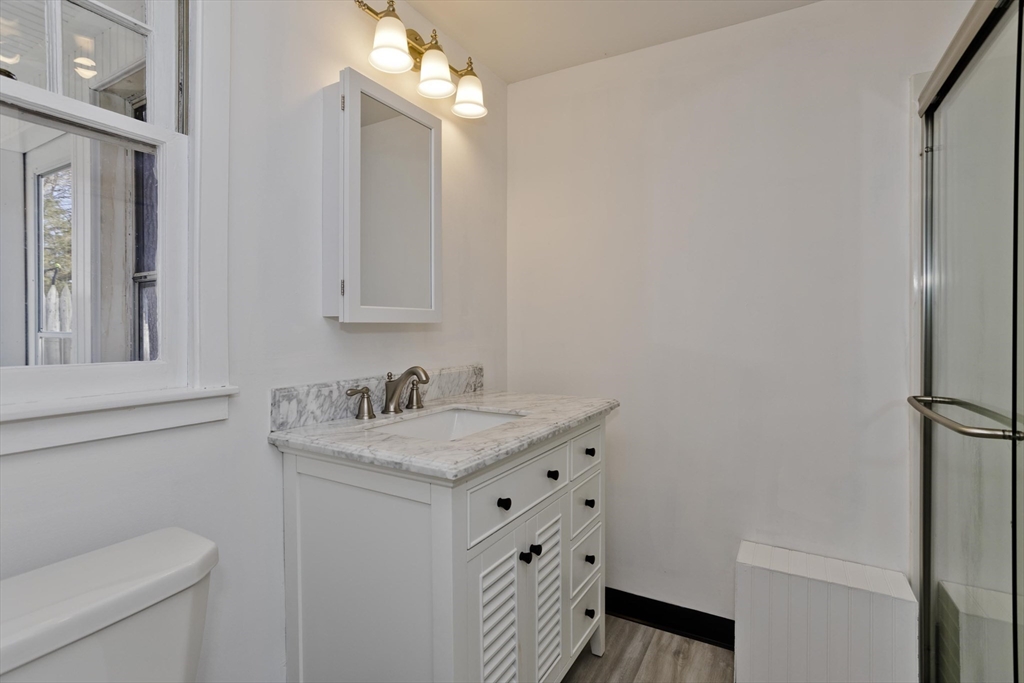 53 Champlain Street Springfield, MA 01151 - Photo 22 of 30 a bathroom with a granite countertop sink toilet and a mirror