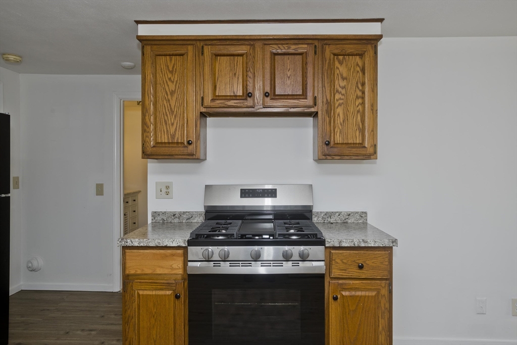 53 Champlain Street Springfield, MA 01151 - Photo 8 of 30 a kitchen with granite countertop a stove top oven cabinetry a sink and a window