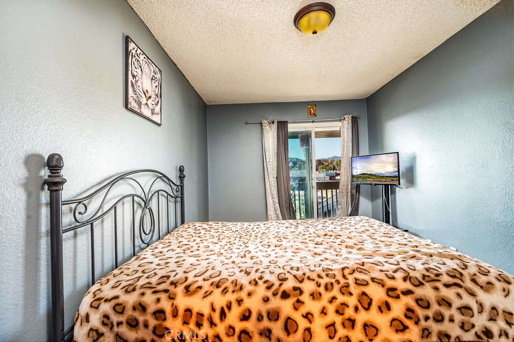 25899 Baylor Way Hemet, CA 92544 - Photo 16 of 29 a bedroom with a bed and a large window