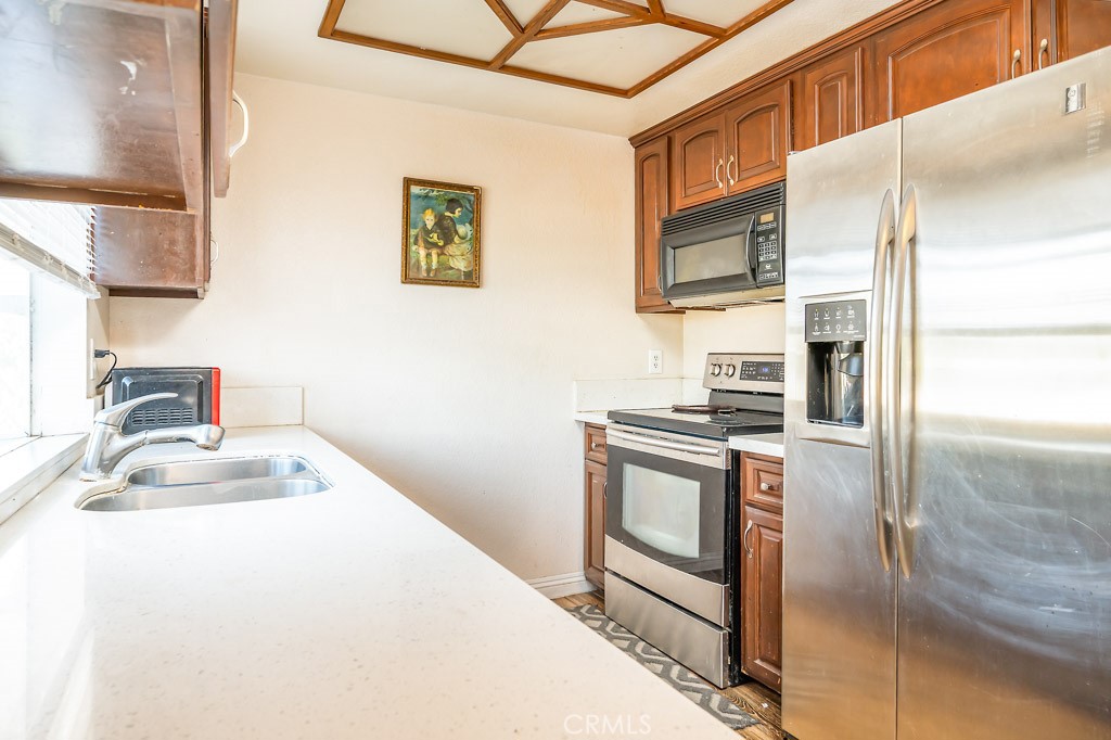 25899 Baylor Way Hemet, CA 92544 - Photo 8 of 29 a kitchen with stainless steel appliances granite countertop a sink a stove and a refrigerator