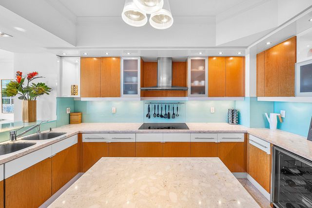 a kitchen with stainless steel appliances granite countertop a sink and a refrigerator