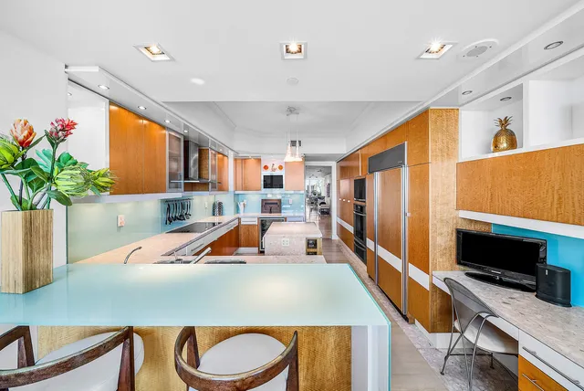 a living room with dining table and a potted plant