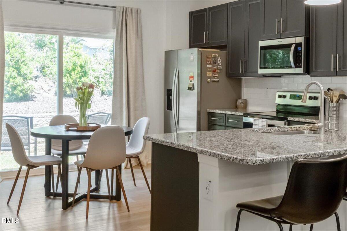517 Hacksaw Trail Raleigh, NC 27610 - Photo 6 of 20 a kitchen with a table chairs refrigerator and cabinets