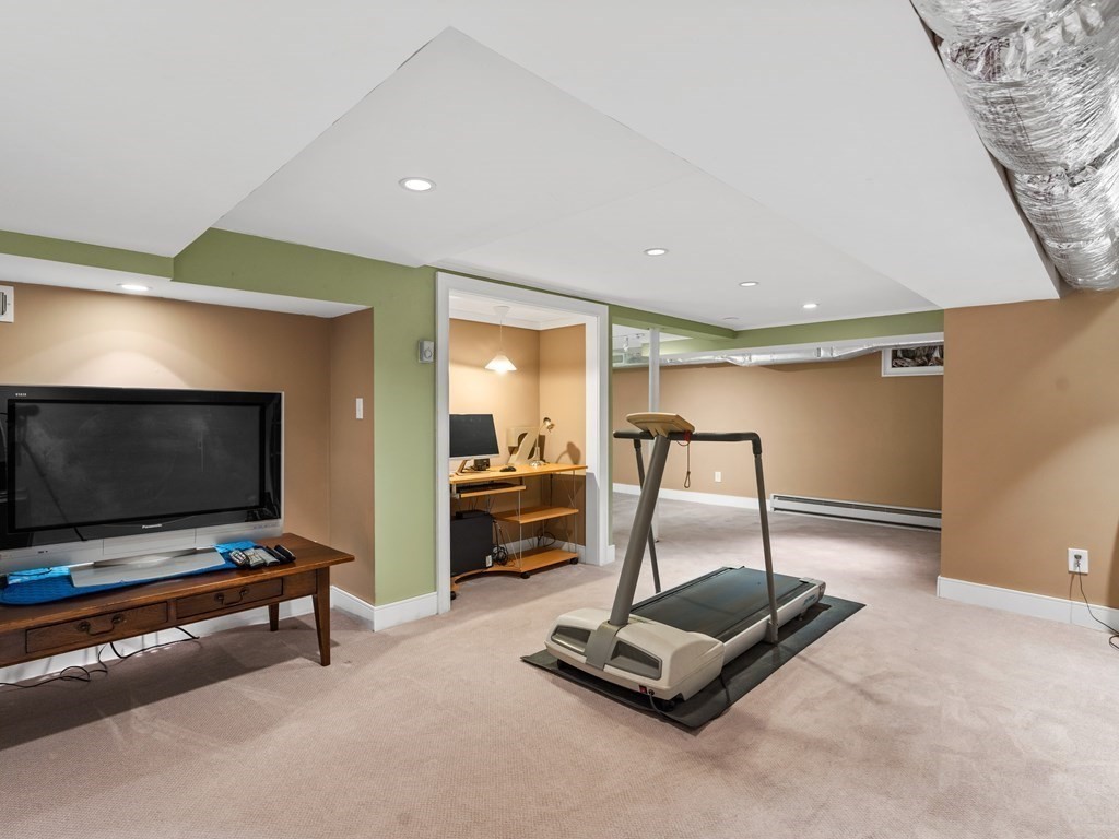 41 Sawyer Road Wellesley, MA 02481 - Photo 22 of 28 a living room with gym equipment and a flat screen tv