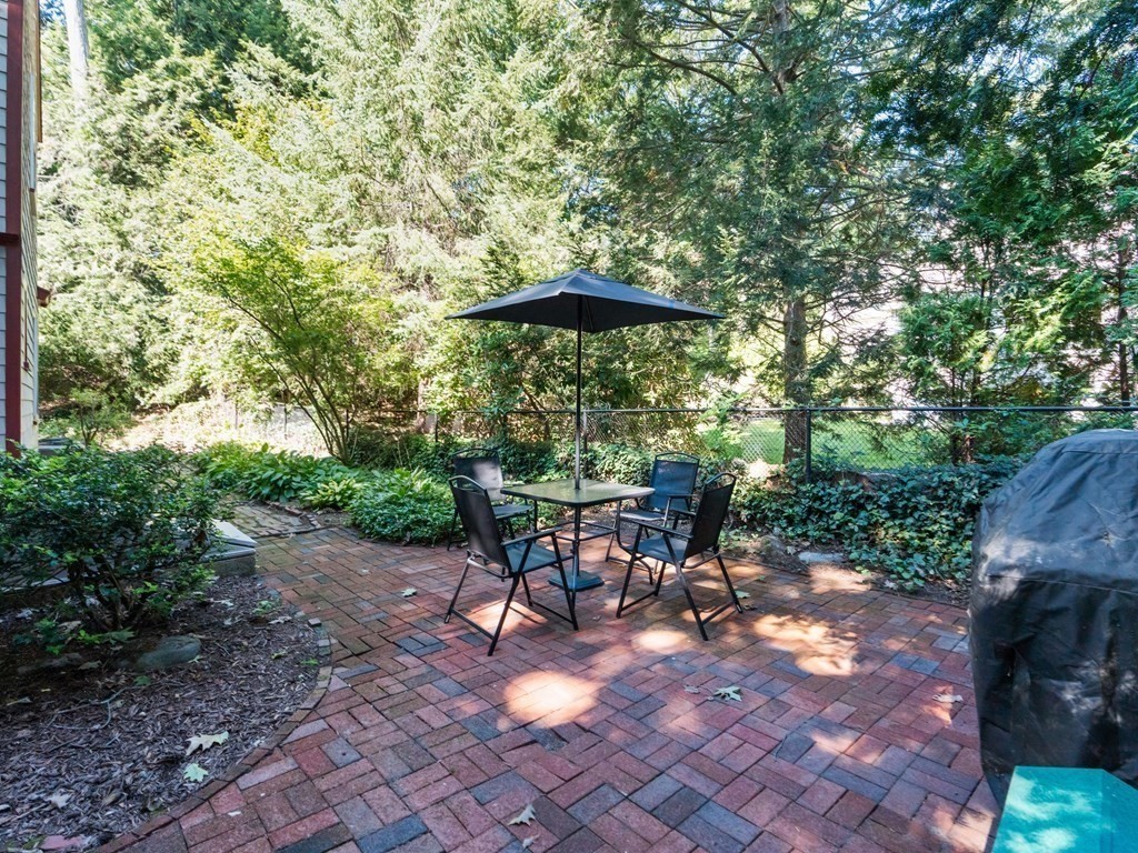 41 Sawyer Road Wellesley, MA 02481 - Photo 25 of 28 a view of a patio with table and chairs under an umbrella
