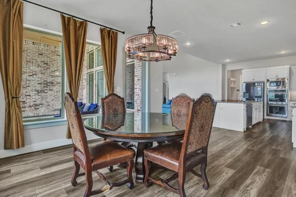 a dining room with furniture a chandelier and wooden floor