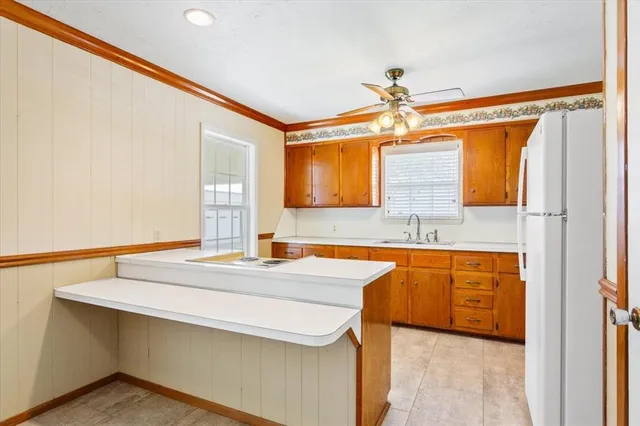 a kitchen with stainless steel appliances a sink dishwasher a stove and a refrigerator with wooden floor