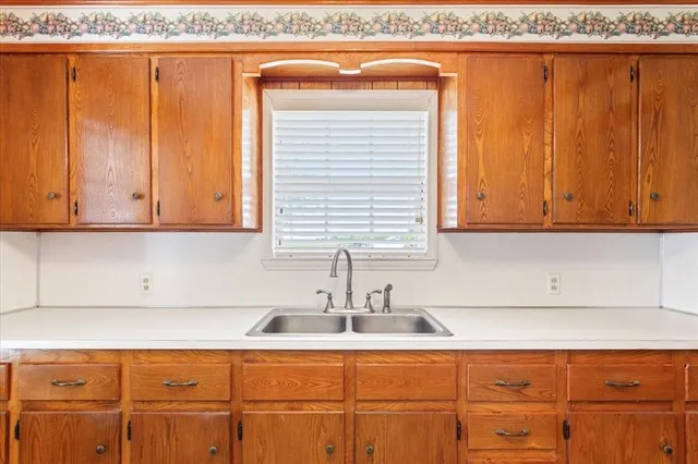 a kitchen with stainless steel appliances granite countertop white cabinets and a sink