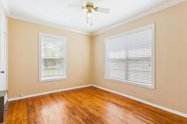 a view of an empty room with a window and wooden floor