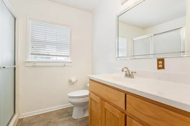 a bathroom with a granite countertop sink toilet and a mirror