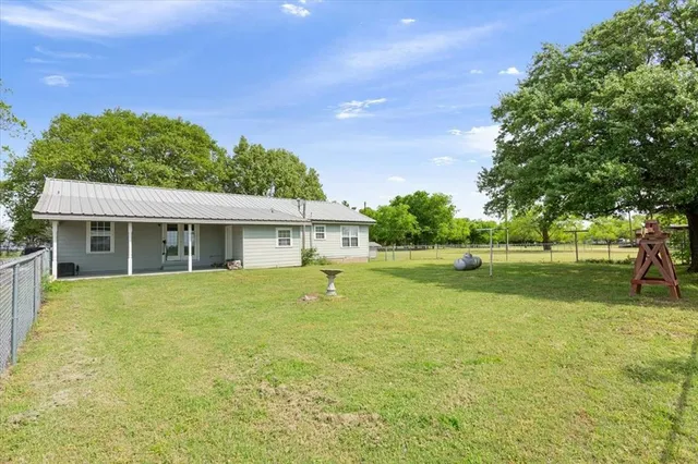 a view of a house with a backyard and a tree