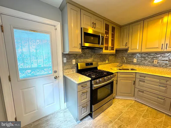 a kitchen with a stove a sink and a microwave