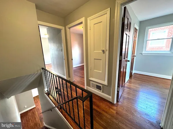a view of a hallway with wooden floor and stairs