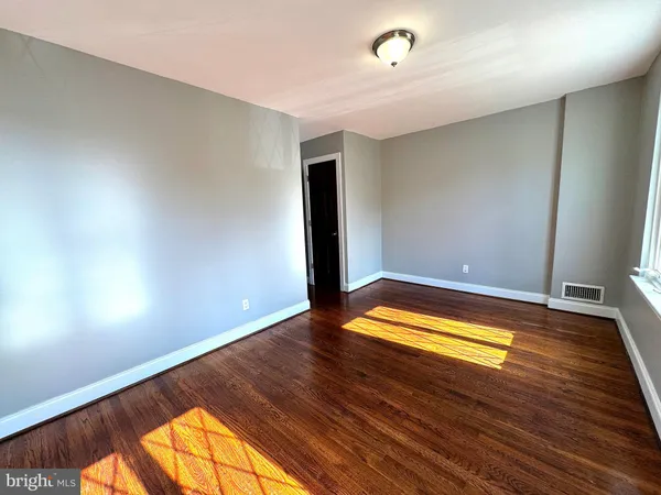 an empty room with wooden floor and a window